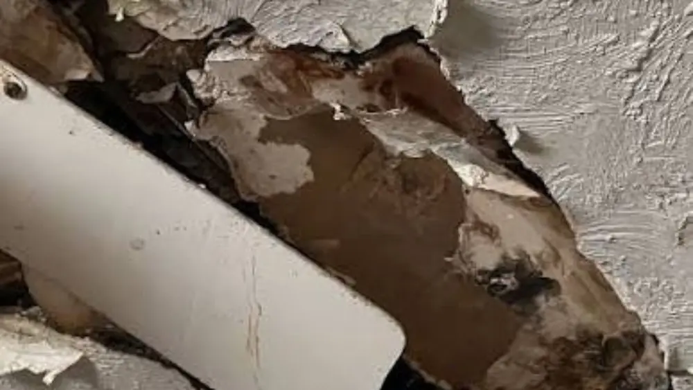 Water-damaged ceiling opened up around a vent pipe